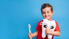 Un ni�o posa con su cepillo de dientes.