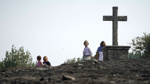 Varias personas en la zona quemada en las proximidades del Santuario de la Virgen del Acebo, en Asturias