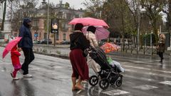 Padres con ni�os en una calle de Sevilla.