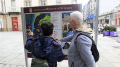 Una pareja de turistas consultan un panel informativo en el centro de Monforte