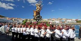Los costaleros llevan el paso con la imagen de la Virgen del Carmen de camino al barco para la procesi�n mar�tima.