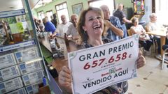 Mari Carmen Rodr�guez muy contenta con el n�mero premiado en el bar Malpica, en Mani�os (Fene)