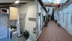 En la primera imagen, el interior del piso de los ocho metros cuadrados. Encima de la mesa de estudio est� la vitrocer�mica pot�til y encima del armario est� el microondas. En la segunda fotograf�a, el patio de vecinos en el que, seg�n el anunciante, est� situado el v�ter.