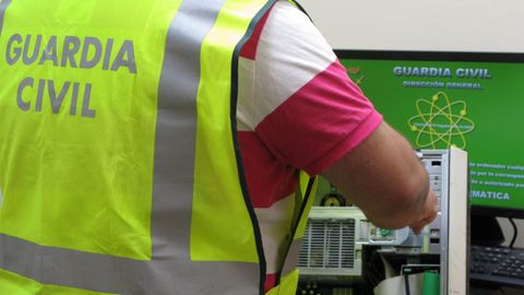 Un guardia civil examina uno de los ordenadores del IES Garc�a Barros de A Estrada. 