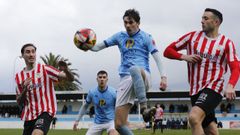 Francisco Rolle golpeando el bal�n ante dos adversarios del Arteixo, en el encuentro disputado en Cantarrana, en Viveiro.