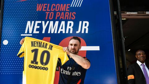 Un aficionado posa con una camiseta amarilla del PSG con el n�mero 10 y el nombre de la estrella brasile�a despu�s de comprarla en la tienda del Paris-Saint-Germain