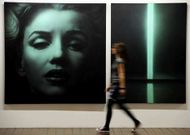 Una mujer pasa ante un retrato de Marilyn en una obra del artista ruso Timofeev.