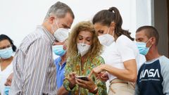 Los reyes atienden a una mujer que les muestra im�genes de su casa antes de ser engullida por la lava