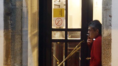 Un cliente fuma en la puerta en 2011, recin estrenada la Ley Antitabaco