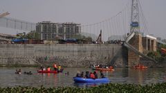 Equipos de rescate trabajan para localizar a los desaparecidos durante el colapso del puente de Morbi.