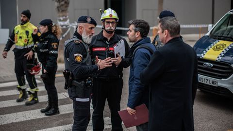 Agentes de la Polic�a Local de Valencia atienden a los vecinos del edificio incendiado el pasado jueves que se sald� con diez v�ctimas mortales