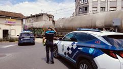 Un Policía Local, esta tarde junto al paso a nivel de A Florida, con el tren que atropelló a la víctima todavía detenido en la vía