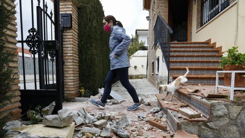 Una joven pasa por encima de unos escombros provocados por el terremoto en Atarfe