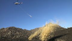 Un helic�ptero arroja paja para impedir el arrastre de cenizas