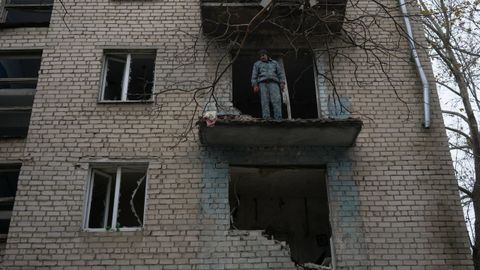 Un hombre se asoma a lo que era el balc�n de su apartamento, en Jers�n, destruido por las bombas durante un ataque ruso