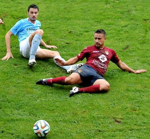 Adri�n Mouri�o intenta reba�ar un bal�n en un lance del partido ante la presi�n de un rival. 