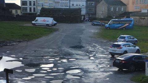 En el aparcamiento hay numerosos socavones, llenos de agua estos das 