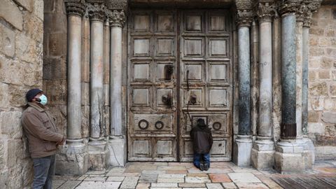 Gente orando a las puertas de la iglesia del Santo Sepulcro, en Jerusaln, donde estn cerrados los lugares de culto