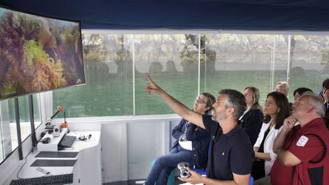 A bordo del Nautilus, Andrés Blanco muestra a las conselleiras imágenes de la flora marina de la isla de San Martiño