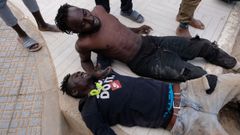 Dos migrantes despus de saltar la valla de Melilla el pasado 24 de junio