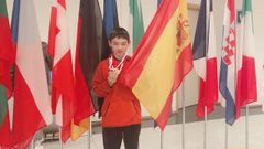 El joven rianxeiro posa con sus medallas junto a la bandera espaola.