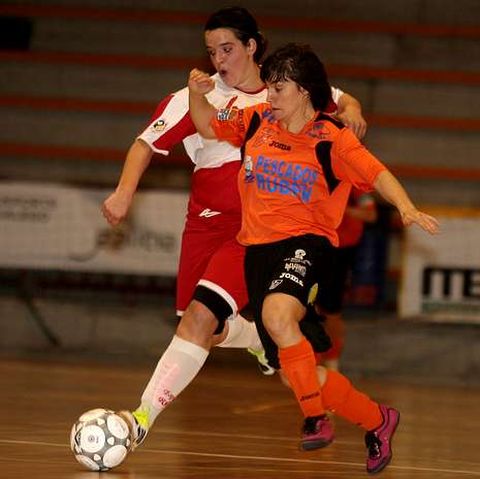 Maite, de naranja, en pugna con una jugadora del Rub�.