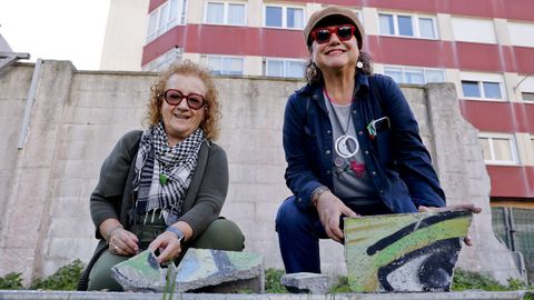 Dos vecinas del Agra do Orz�n posan con restos del muro reci�n derribado.