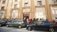 Padres con sus hijos se amontonan en la puerta del edificio