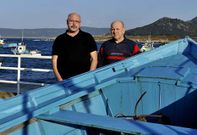 Antonio Mouzo y Manuel Rodr�guez, apoyados en una lancha en el puerto de su Camelle natal.