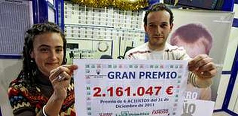 Jorge Anta Fern�ndez, propietario de la Administraci�n n�mero 2, y su pareja, F�tima Gonz�lez, con el cartel del premio.