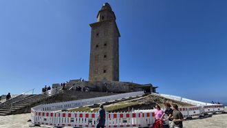 Visitantes al pie de la torre de H�rcules, en la que hay una zona vallada con una zanja desde marzo