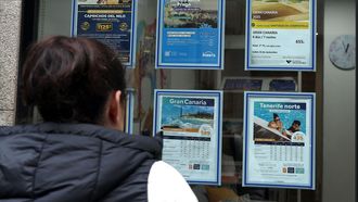 Imagen de archivo de una mujer observando ofertas de viajes de una agencia tradicional