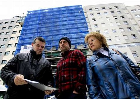 La presidenta de la comunidad junto con dos vecinos del edificio de la plaza de A Mioca.