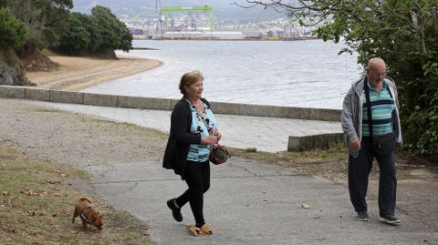 Personas paseando con su mascota ayer en el paseo de Caranza, con la playa al fondo.