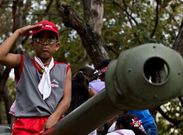 Un ni�o juega en un tanque mientras sus padres hacen cola para ver el f�retro de Ch�vez.