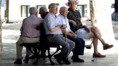 Un grupo de personas mayores sentadas en un banco.