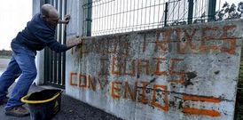 Un operario limpia las pintadas relativas al conflicto que hab�a ayer en el parque de Cee.
