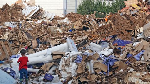 Un ni�o mira la monta�a de escombros arrastrados por el torrente de agua en Oliveral.