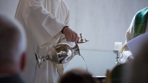 bautismo, bautizo, bautizar, Iglesia.Un párroco preparando la pila bautismal.
