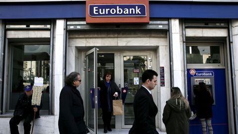 Gente paseando frente a una sucursal bancaria en Atenas