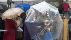 Dos mujeres comprueban un paraguas en un mercadillo de Oviedo