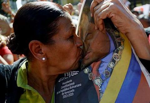 Una mujer besa el retrato de Hugo Ch�vez durante el acto en su homenaje ayer en Caracas.