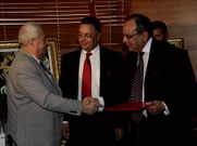 Jove -izquierda- estrecha la mano al representante del Hilton.