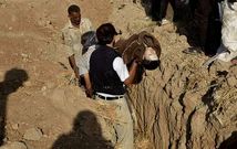 Un hombre sostiene el cuerpo de un ni�o v�ctima de los bombardeos en las afueras de Damasco, antes de ser sepultado en Hamoria.