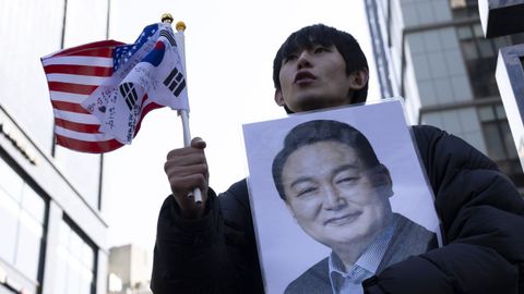 Un seguidor de Yoon Suk-yeol sostiene un retrato del ex primer ministro en el exterior del tribunal que lo juzg�