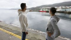 Dos j�venes se�alan el lugar donde se produjo el rescate, en el puerto de Burela