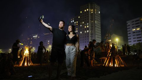Una pareja se hace un selfie entre las hogueras