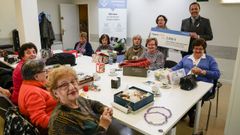 Las mujeres voluntarias de los talleres del Espazo +60  entregaron un cheque a la AECC.
