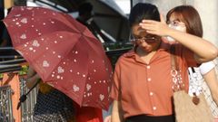 Una mujer se protege del calor extremo que se est� registrando desde hace unos d�as en Bangkok (Tailandia)