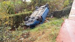 El coche acab volcado tras llevarse parte de una senda peatonal.